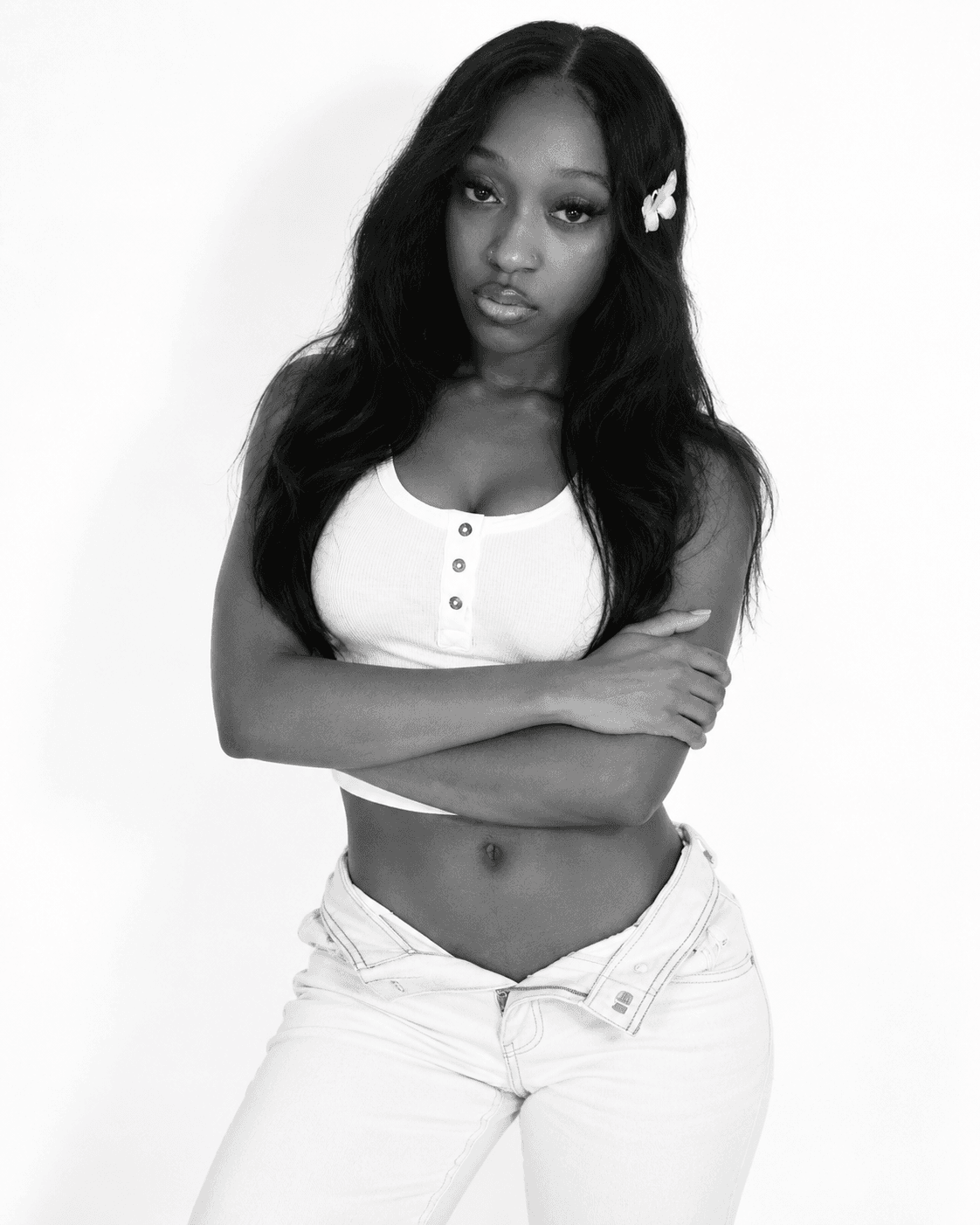 Black and white studio portrait in a white tank and jeans